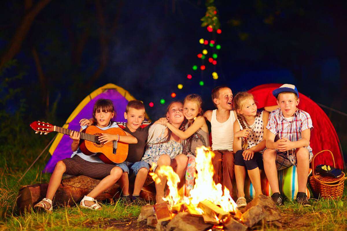 copii canta afara chitara cort foc veselie activitate educativa